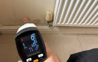 Thermal camera pointed at a damp patch on the wall behind a radiator